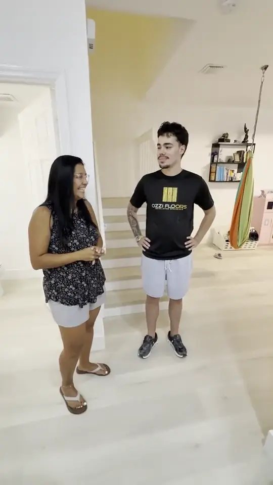 An Ozzifloors team member talking with a customer at the foot of her staircase on a newly installed light plank floor